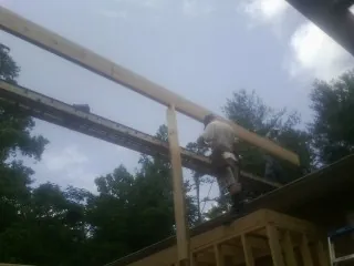 Carpenter setting a ridge beam over a new addition frame — Ice Dam Removal by Roofing Brothers in Savona