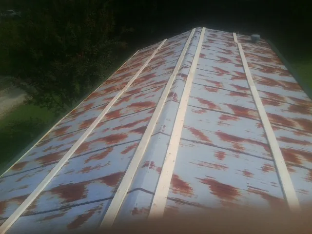 Rusted metal roof panels with new wood purlins before replacement — Storm Damage Roof Repair in Savona by Roofing Brothers